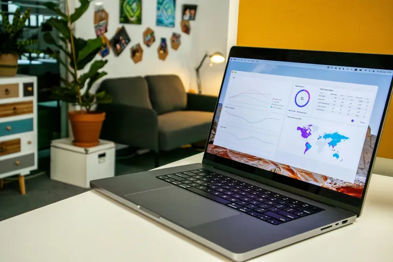 A laptop showing a website traffic dashboard in a bright office