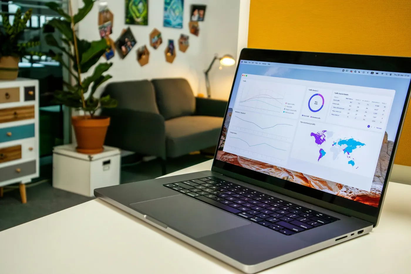 A laptop showing a website traffic dashboard in a bright office
