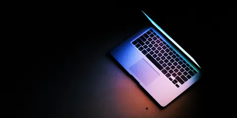Laptop glowing in a dark room