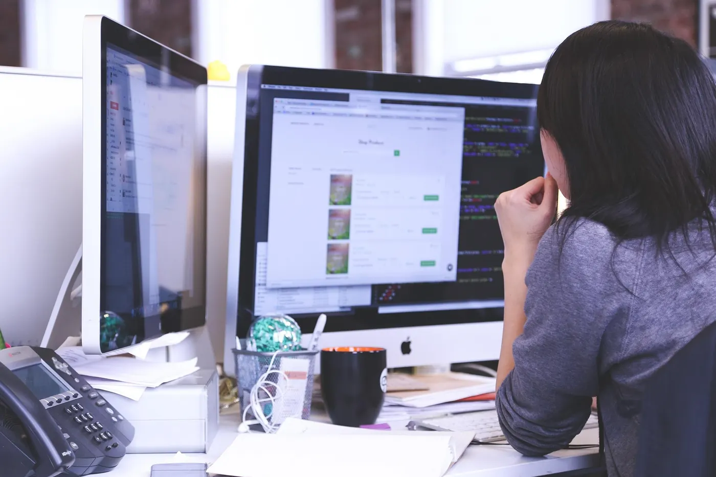 A web designer reviewing a site build across two monitors